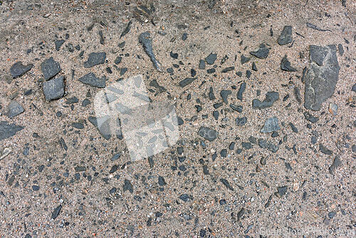 Image of Textured surface featuring fragments of stone and gravel in a gr