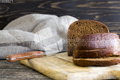 Image of bread sliced on wooden cutting Board