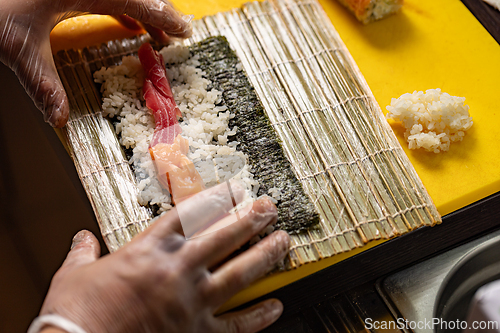 Image of Chef preparing sushi rolls