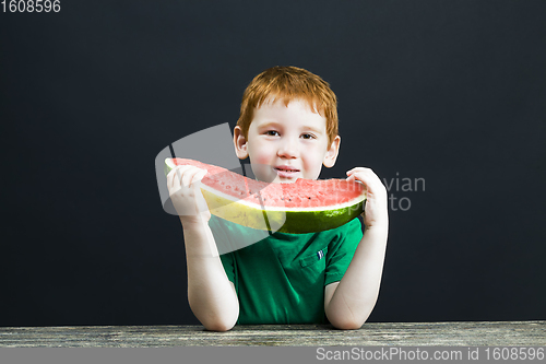 Image of boy eats a red watermelon