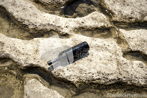 Image of Bottle of wine on the shore.