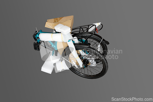 Image of Compact bicycle in packaging prepared for shipping on grey background ready to be sent to customers.