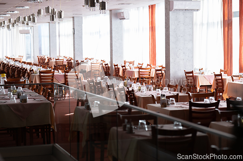 Image of Empty restaurant dining hall with arranged tables and chairs