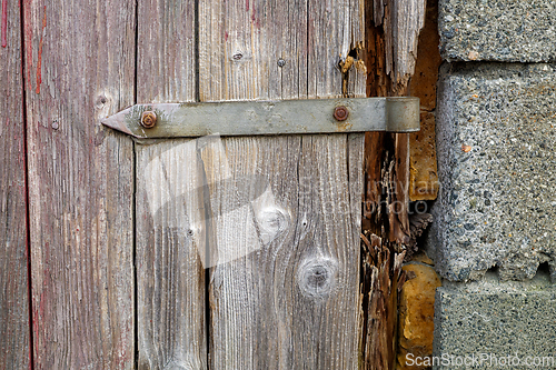 Image of Wooden door with metal latch showing signs of wear and weatherin