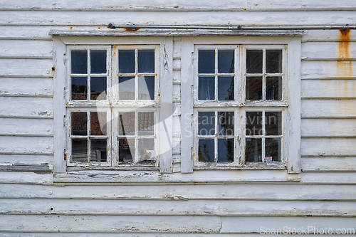 Image of Weathered windows on a rustic wooden building reflecting the sur