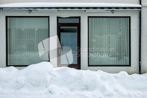 Image of Winter scene with an empty storefront covered in snow in an urba