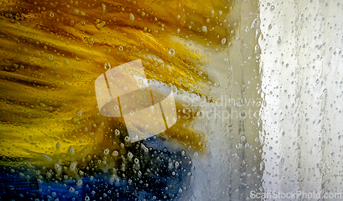 Image of Colorful water spray from a car wash machine cleans vehicles on 