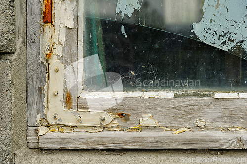 Image of Weathered wooden window frame showcasing peeling paint and crack