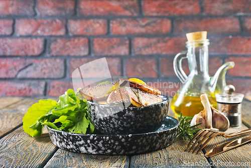 Image of Bowl with baked potatoes on wooden background