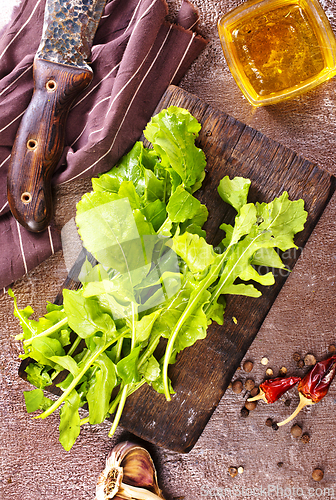 Image of Fresh arugula leaves, rucola on wooden board