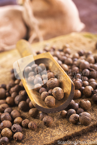 Image of Pile of Black peppercorns seeds on stone board