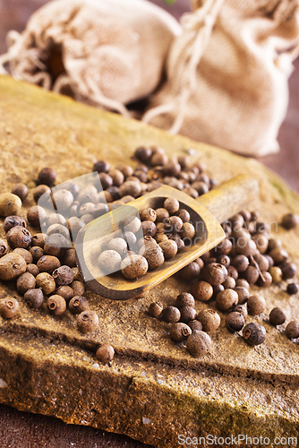 Image of Pile of Black peppercorns seeds on stone board