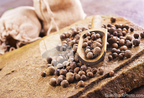 Image of Pile of Black peppercorns seeds on stone board