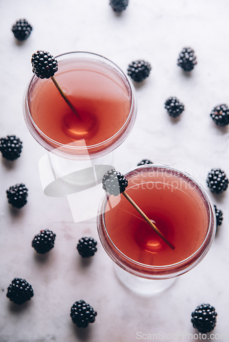 Image of Blackberry gin cocktail in martini glass garnish with fruit on l