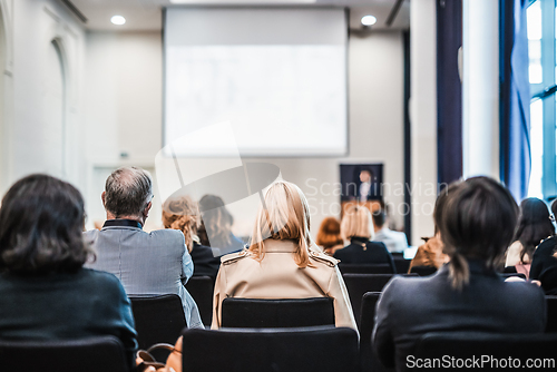 Image of Speaker giving a talk in conference hall at business event. Rear view of unrecognizable people in audience at the conference hall. Business and entrepreneurship concept.