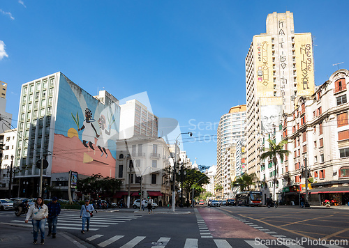 Image of Street view of downtown Sao Paulo, with people on a crosswalk and traffic on the road. Brazil