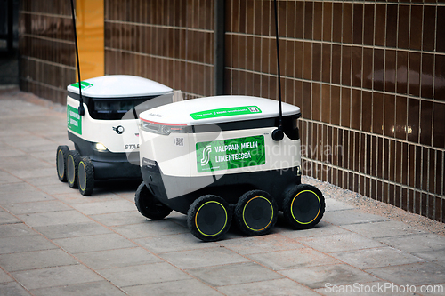 Image of Two Starship Food Delivery Robots Outside Grocery Store