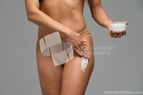 Image of Close-up of woman moisturizing shoulder with cream showing self care