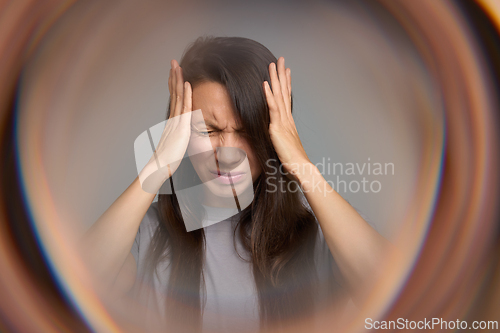 Image of Woman closing eyes in pain suffering from migraine aura and sensory overload