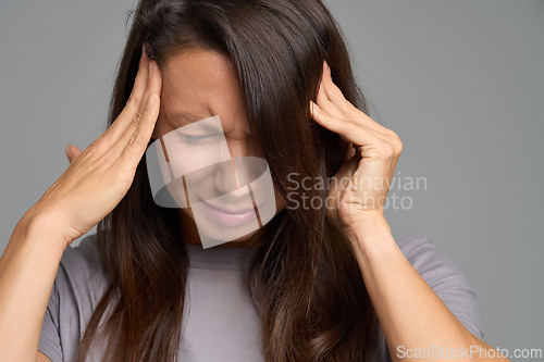 Image of Close-up of woman squeezing eyes and pressing temples, severe migraine pain