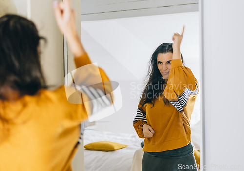 Image of Self confident single woman pointing finger at reflection in mir