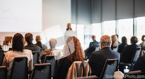Image of Female speaker giving a talk on corporate business conference. Unrecognizable people in audience at conference hall. Business and Entrepreneurship event.