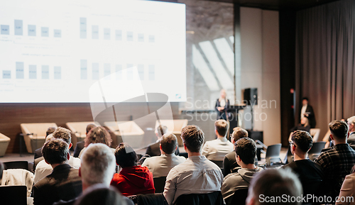 Image of Female speaker giving a talk on corporate business conference. Unrecognizable people in audience at conference hall. Business and Entrepreneurship event.