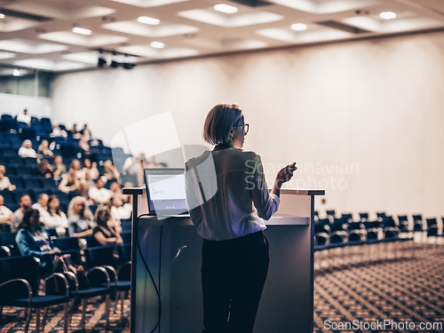 Image of Female speaker giving a talk on corporate business conference. U