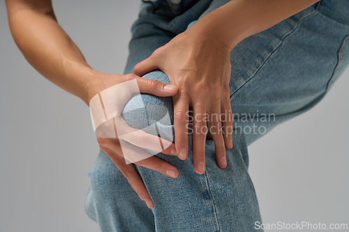 Image of Close-up of woman touching her knee showing discomfort and joint pain