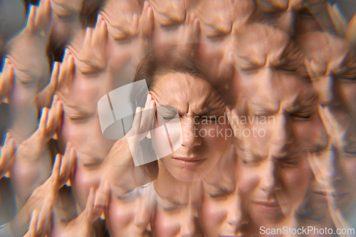 Image of Close-up portrait of woman holding her head in pain with headache effect