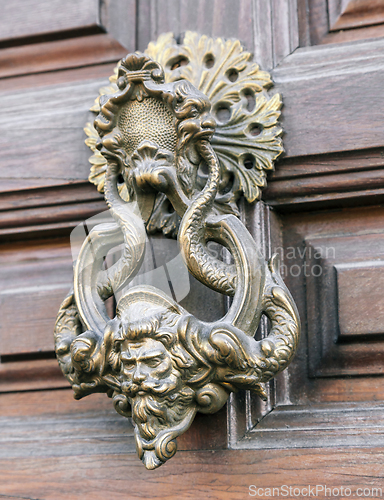 Image of Old door knocker on a wooden door