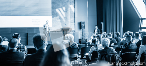 Image of Speaker giving a talk in conference hall at business event. Business and entrepreneurship concept. Blue toned black and white image.