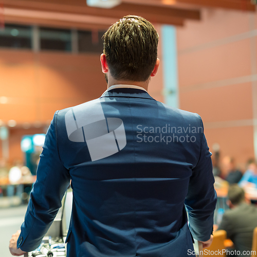 Image of Public speaker giving talk at Business Event.