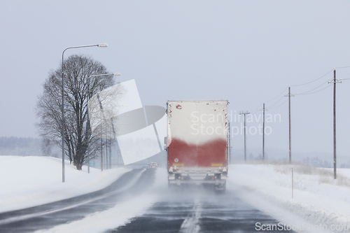 Image of Semi Truck Driving in Snowfall