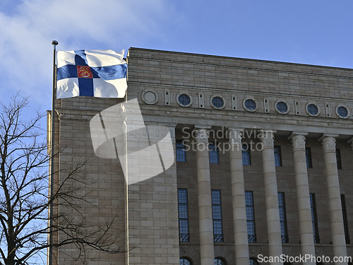 Image of waving Finnish flag and Finnish parliament building 