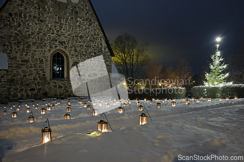 Image of lanterns and a Christmas tree in a church cemetery in the small 