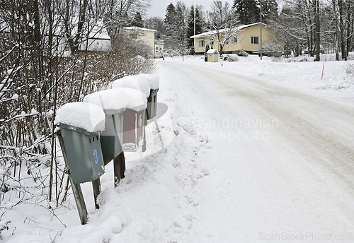 Image of snow covered mailboxes and a road in a small Finnish town