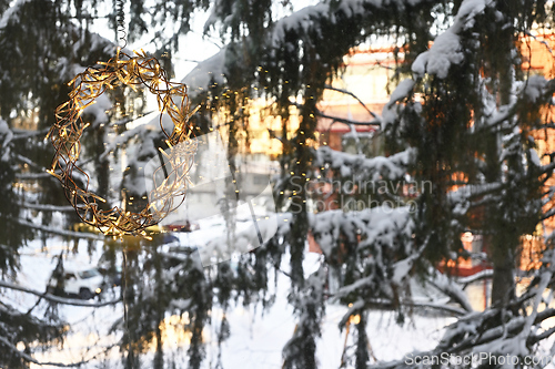 Image of Christmas garland on the window, and snow covered fir trees 