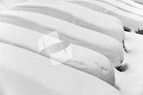 Image of cars covered with snow in the parking lot 