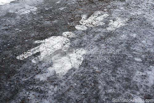 Image of  Ice covered sidewalk with a pedestrian path sign 