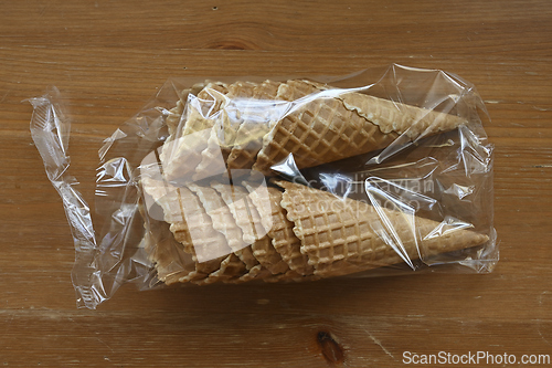 Image of waffle cones in plastic packaging on a wooden table 