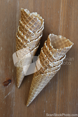 Image of Two empty waffle cones on a wooden table 