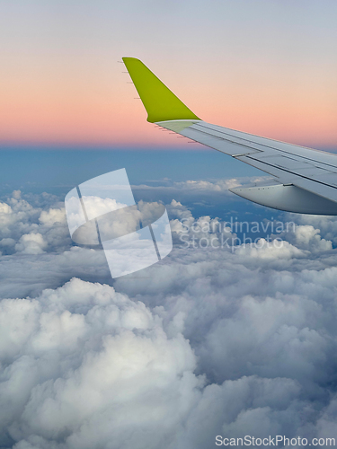 Image of Wing of an airplane flying above the clouds