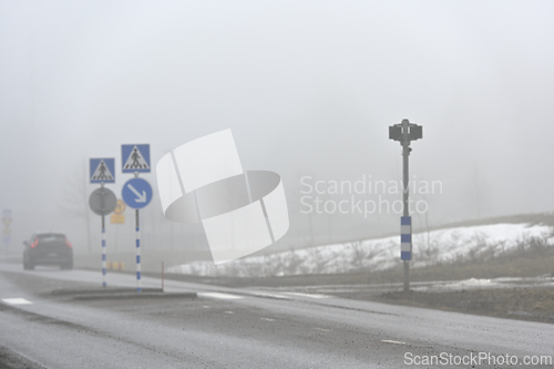 Image of blurred image of a pedestrian crossing and a car in the fog 