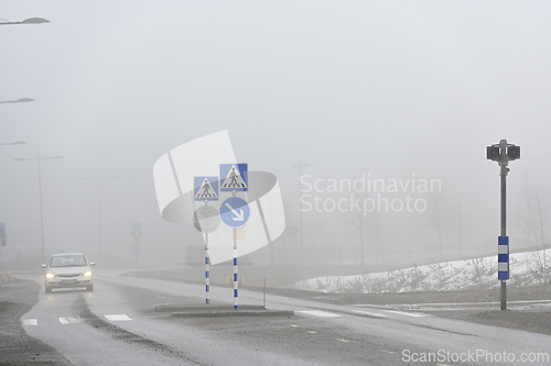 Image of pedestrian crossing and car in the fog 
