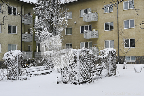 Image of Snow-covered residential building with trees
