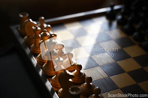 Image of wooden chess pieces on an old board 