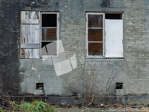 Image of Forgotten windows reveal stories of an abandoned structure in a 