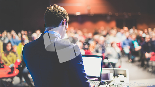Image of Public speaker giving talk at business event.