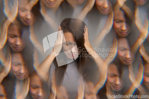Image of Stressed woman suffering from headache holding her head with hands